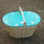 Picnic basket with hand painted aqua wooden lid surrounded with daisies and vines.
